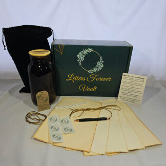 A green box labeled Memory Vault is shown with a black pouch, large jar, paper sheets, string, pen, envelope stickers, and an instruction card arranged on a light surface.